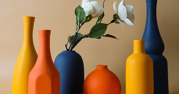 Collection de vases décoratifs en céramique aux teintes orange, jaune et bleu marine, avec fleurs blanches artificielles, sur fond beige - Benigna Nunes Pinterest