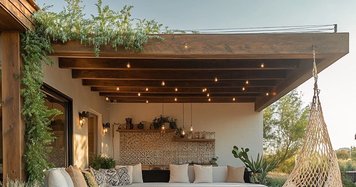 Terrasse extérieure moderne en bois avec coin lounge, canapé blanc, foyer central et chaise suspendue dans une ambiance chaleureuse et naturelle par House Design Pinterest