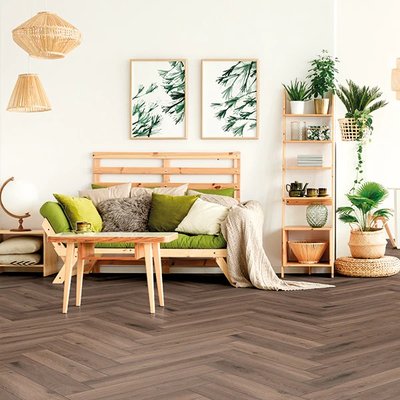 Plancher stratifié en chevrons Ferrara de la collection Authentic Herringbone AC4 chez Plancher 2000, dans un salon au style bohème et végétal