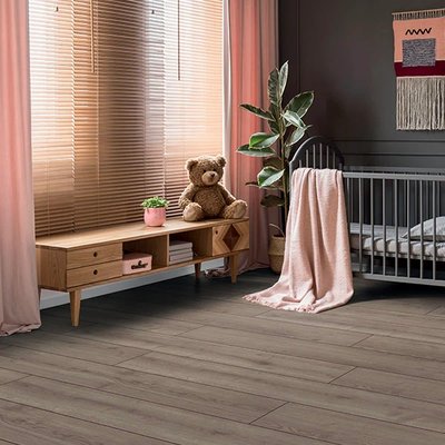 Plancher stratifié gris foncé Elios AC5 de la collection Authentique Ocean par Plancher 2000 dans une chambre de bébé au décor chaleureux