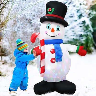 Jeune enfant en habit d'hiver bleu interagissant joyeusement avec un bonhomme de neige gonflable lumineux, portant un chapeau haut-de-forme, une écharpe bleue et tenant une canne en sucre d'orge, dans un décor enneigé - Amazon