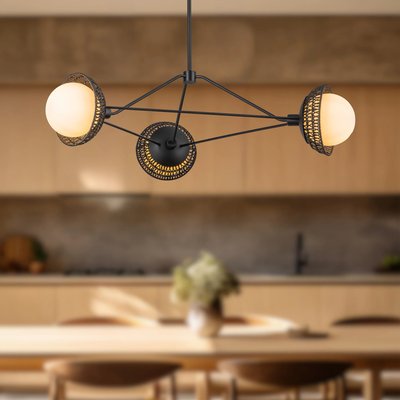 Chandelier Perth suspendu avec trois globes lumineux en verre opalin de chez Luminaires & Cie, entourés de grilles métalliques ajourées noires, dans une cuisine moderne au décor minimaliste et tons naturels