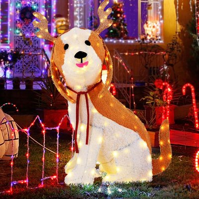 Décoration lumineuse extérieure représentant un chien déguisé en renne de Noël, entouré de lumières colorées et de cannes de bonbon, devant une maison décorée pour les fêtes - Amazon