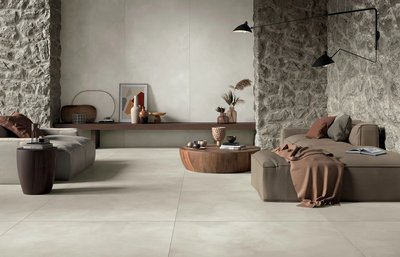 Salon élégant aux murs de pierre et céramique effet béton beige clair de la collection Clay, chez Céramique l’Entrepôt