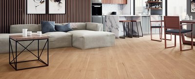 Salon moderne avec plancher de bois franc pâle de la collection Cool Sage de Fuzion Flooring, décoré de meubles contemporains et d'une cuisine au design marbré.
