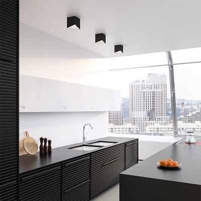 Cuisine moderne minimaliste avec des plafonniers cubiques noirs Cubix, offrant un éclairage épuré dans un espace urbain avec vue panoramique – Maison du Luminaire