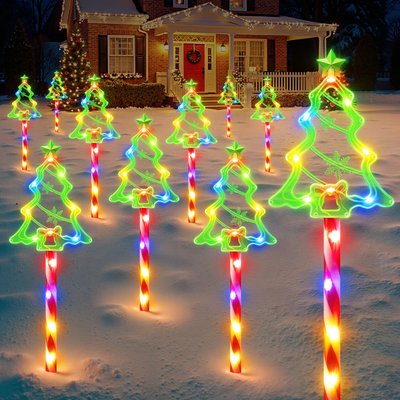 Décorations lumineuses de Noël en forme de sapins verts sur des bâtons de sucre d'orge éclairés, alignées sur une pelouse enneigée devant une maison décorée - Wayfair