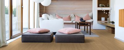 Salon lumineux avec plancher de bois franc pâle de la collection Éclair de Fuzion Flooring, décoré de coussins rayés rouges et blancs.