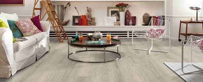 Salon lumineux avec plancher en vinyle Frontenac de Fuzion Flooring, décor éclectique avec fauteuils modernes et table basse ronde.