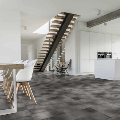 Aire ouverte au style contemporain avec escalier architectural et plancher vinyle effet béton foncé, collection Futura Echo de Céramique l’Entrepôt