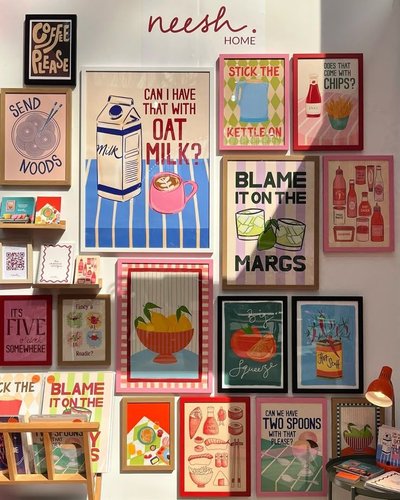 Mur décoratif avec des affiches colorées et humoristiques de style pop art exposées chez Neesh Home, incluant des citations ludiques et des illustrations liées à la nourriture et aux boissons Source - Haven Decor Pinterest