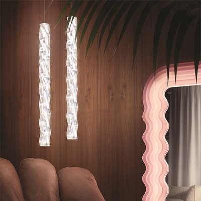 Suspensions verticales Hugo de Slamp diffusant une lumière douce, installées dans un intérieur rétro chic avec miroir ondulé rose – Maison du Luminaire
