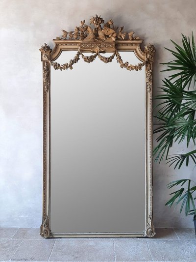 Grand miroir ancien avec cadre sculpté doré orné de guirlandes florales et de deux oiseaux au sommet