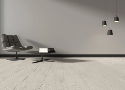 Espace minimaliste avec fauteuil moderne et plancher flottant gris pâle de la collection Izmir Dawson, chez Céramique l’Entrepôt