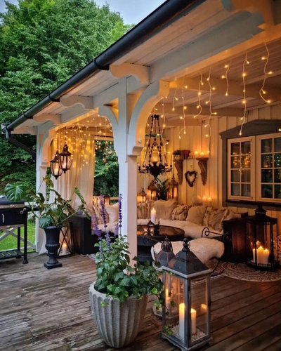 Terrasse rustique avec toit couvert, décorée de lumières suspendues Source - Jennifer Hoebel Pinterest Terrasse rustique avec toit couvert, décorée de lumières suspendues, lanternes, plantes en pot et coussins douillets, créant une ambiance cosy en soirée d'été Source - Jennifer Hoebel Pinterest