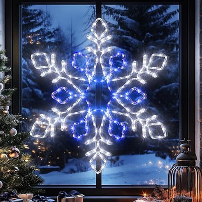 Grande décoration flocon de neige lumineux blanc et bleu fixée à une fenêtre, avec un paysage hivernal enneigé en arrière-plan - Amazon