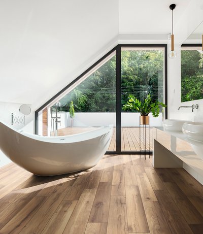 Salle de bain moderne avec baignoire autoportante et plancher stratifié effet bois Laguna par Fuzion Flooring