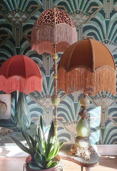 Photo par Ame Ame Lampe de table éclectique avec pied en pierre verte et abat-jour à franges, entourée d'autres modèles rétro, photo Pinterest