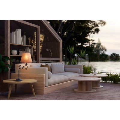 Lampe de table avec abat-jour en tissu orange posée sur une table basse en bois dans un salon extérieur au bord de l'eau, photo par Luminaires & cie