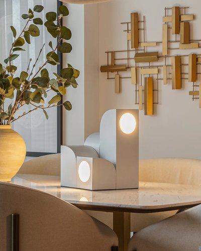 Lampe de table géométrique moderne avec éclairage circulaire, posée sur une table en marbre, photo par Luminaires & cie