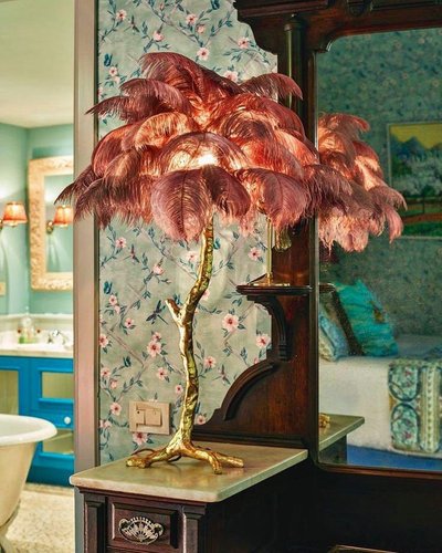 Lampe de table avec pied doré en forme de tronc et abat-jour composé de plumes roses, posée sur un meuble ancien, Image Pinterest