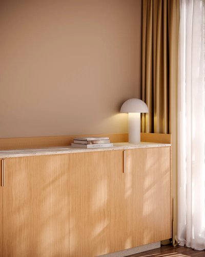 Lampe de table au design minimaliste avec abat-jour en forme de dôme, posée sur un meuble en bois clair près d'une fenêtre, photo par Luminaires & cie