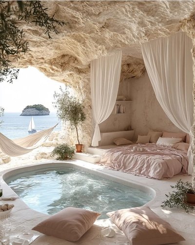 Chambre élégante creusée dans la roche avec lit drapé, piscine intérieure et vue sur la mer avec voilier et une île en arrière-plan Source - Laura Pinterest
