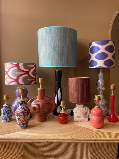 Photo par Madame Garage, Collection de lampes de table colorées et éclectiques présentée sur une console en bois, image Pinterest