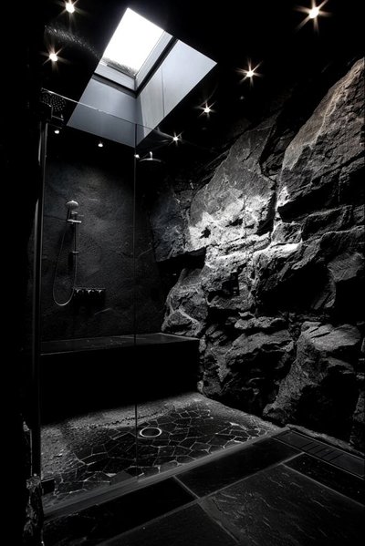 Douche contemporaine au design minéral avec murs en pierre naturelle, éclairage encastré tamisé et puits de lumière offrant une ambiance de spa haut de gamme Source - Madiyar Pinterest