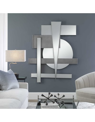 Miroir mural géométrique moderne de chez Ô Miroir, composé de formes rectangulaires et rondes argentées dans un salon aux tons gris et bleus.