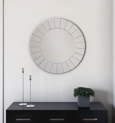 Miroir Kailey de chez Brick – Miroir mural rond décoratif avec encadrement moderne en segments, accroché au-dessus d’une console noire minimaliste avec chandeliers et plante décorative.