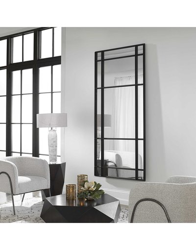 Miroir mural rectangulaire à croisillons noirs de chez Ô Miroir, installé dans un salon lumineux au mobilier contemporain gris et noir.
