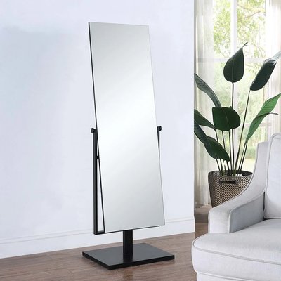 Miroir sur pied pivotant avec cadre noir moderne de Lovaco, placé dans un salon lumineux avec plante verte et fauteuil blanc.