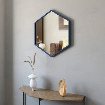 Miroir Zona de chez Brick – Miroir mural hexagonal avec cadre bleu moderne, suspendu au-dessus d’une console en bois minimaliste décorée de vases design.