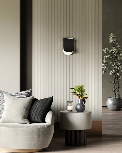 Luminaire mural noir et blanc modèle Sonder de chez Luminaires & Cie, installé sur un mur à panneaux verticaux beige dans un salon moderne avec fauteuil arrondi, table d'appoint décorative et plante verte