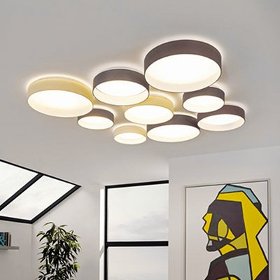 Plafonnier moderne Palomaro composé de disques lumineux superposés, installé dans un salon lumineux au décor artistique et contemporain – Maison du Luminaire