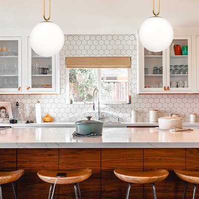 Cuisine lumineuse au style moderne avec dosseret en carreaux hexagonaux, îlot central en bois et luminaires suspendus ronds Prospect de Maison du Luminaire