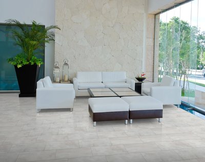 Plancher vinyle RigidTile Firm Premier Capri au fini mat dans un salon contemporain avec mobilier blanc et mur en pierre naturelle, chez Plancher 2000