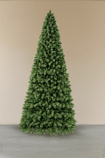Sapin de Noël artificiel vert, non décoré, placé à l'intérieur sur un sol gris avec un mur beige en arrière-plan - Décors Véronneau