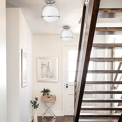 Luminaire semi-encastré Somerset au design sphérique blanc et métal chrome, éclairant un hall d'entrée épuré avec escalier en bois – Maison du Luminaire