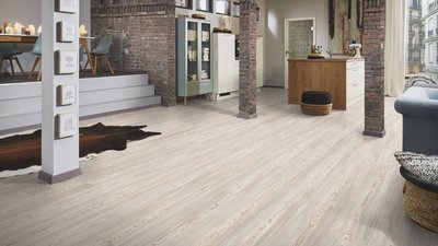 Espace à aire ouverte avec plancher stratifié Water Lily de Fuzion Flooring au fini bois pâle et ambiance urbaine chic