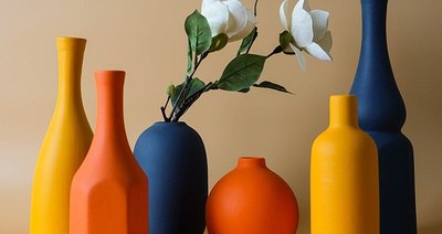 Collection de vases décoratifs en céramique aux teintes orange, jaune et bleu marine, avec fleurs blanches artificielles, sur fond beige - Benigna Nunes Pinterest