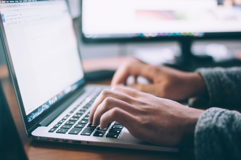 Personne tapant sur un ordinateur portable avec un écran en arrière-plan Personne tapant sur un ordinateur portable avec un écran en arrière-plan, illustrant le travail numérique et la productivité.