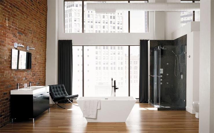 Salle de bain contemporaine avec baignoire autoportante, douche vitrée et mur de briques apparentes par EAU Salle de Bain et Cuisine