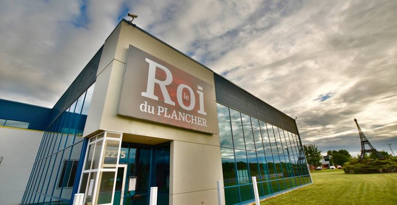 Façade du magasin Le Roi du Plancher, spécialisée en vente de planchers de bois franc, vinyle et céramique, offrant un vaste choix de revêtements de sol de qualité avec salle de montre moderne et service personnalisé.