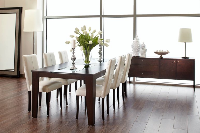 Salle à manger moderne avec table en bois foncé de chez l'entreprise Verbois Salle à manger moderne avec table en bois foncé, chaises blanches et décor épuré de chez l'entreprise Verbois.