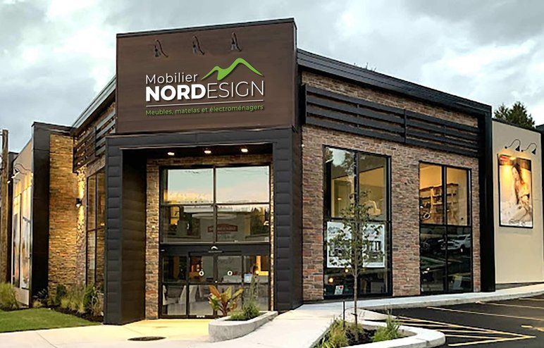 Façade du magasin Mobilier Nord Design Devanture du magasin Mobilier Nord Design, spécialisé en meubles, matelas et électroménagers, avec une architecture moderne en briques et de grandes fenêtres.