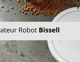 Aspirateur robot Bissell en action sur un sol avec des miettes, nettoyage efficace automatique